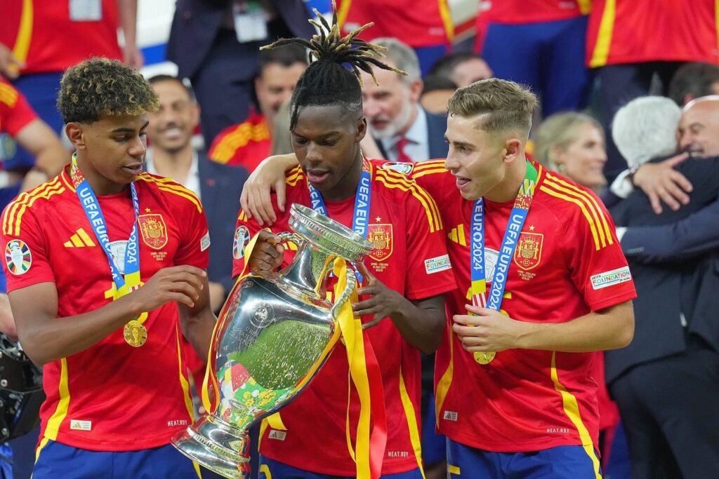 Lamine Yamal e Nico Williams jogando pela Espanha, celebrando gols ou levantando a taça.